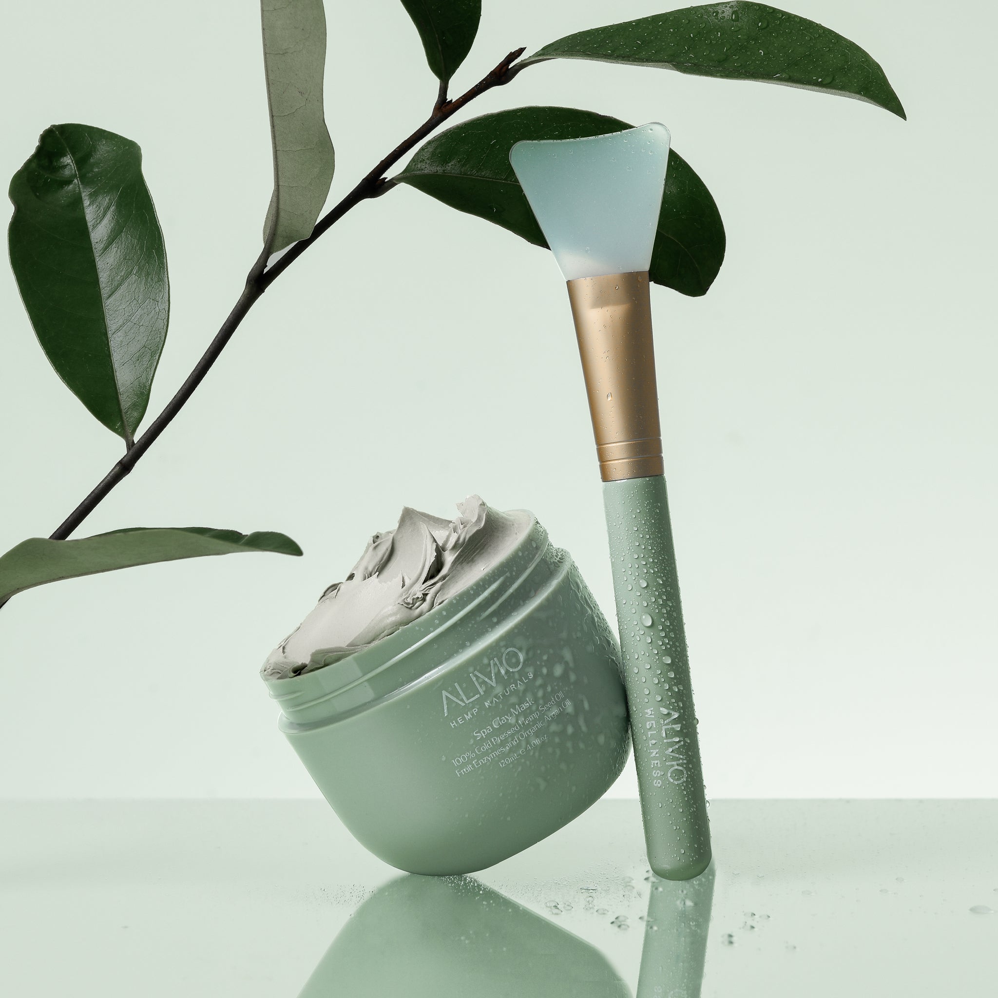 Open tub of Alivio Clay Mask with a silicone applicator brush for mess-free application and deep cleansing.