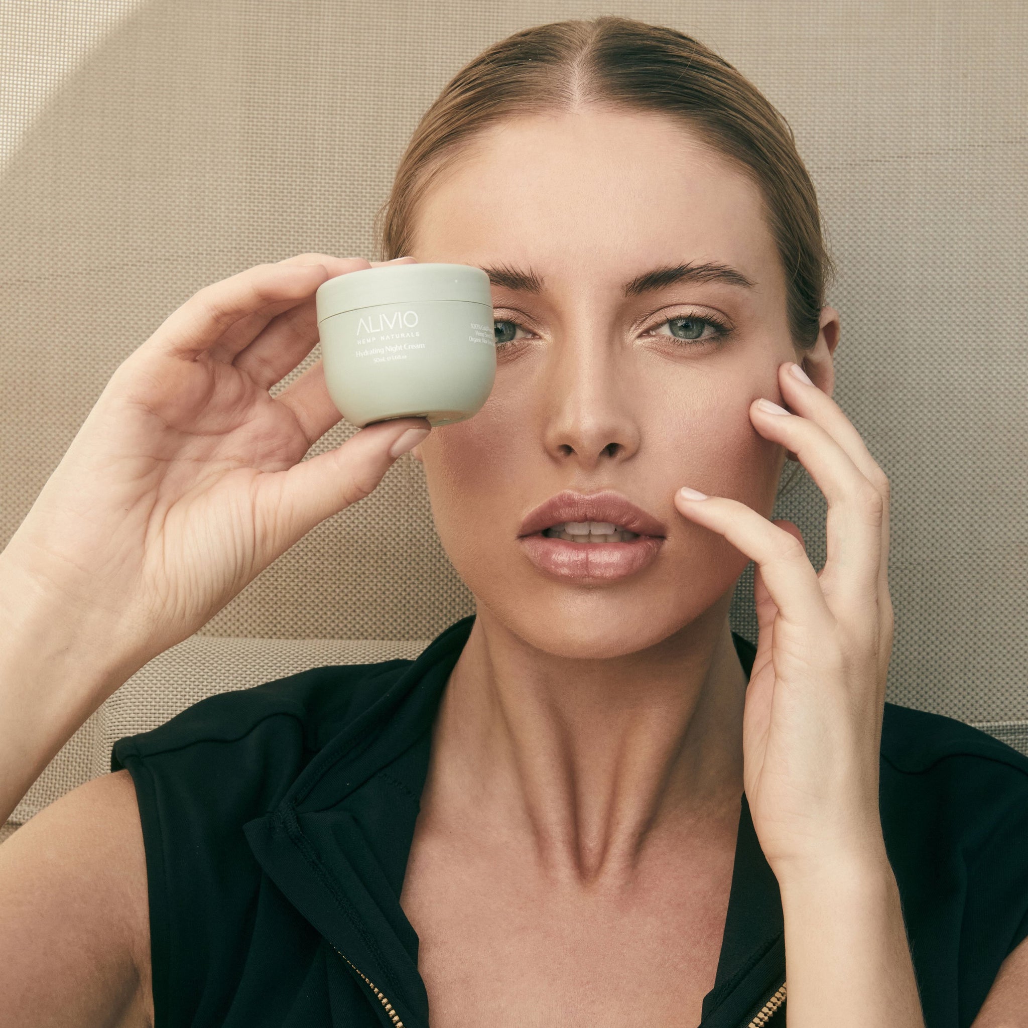 Woman holding Alivio Welless Hydrating Night Cream, part of Sleep Bundle. This nourishing moisturizer deeply hydrates overnight for a radiant and revitalized complexion by morning.