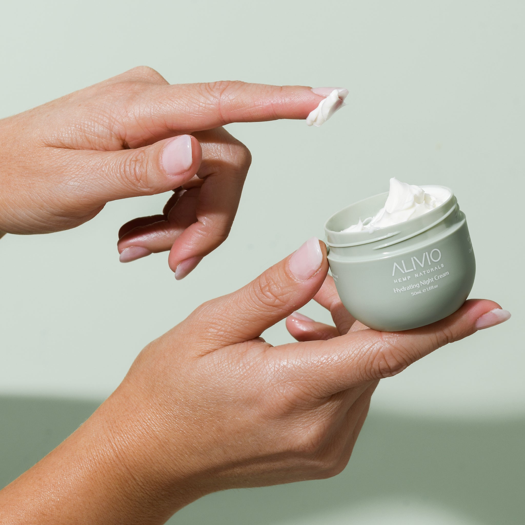 open tub of hydrating night cream with finger shopping contents