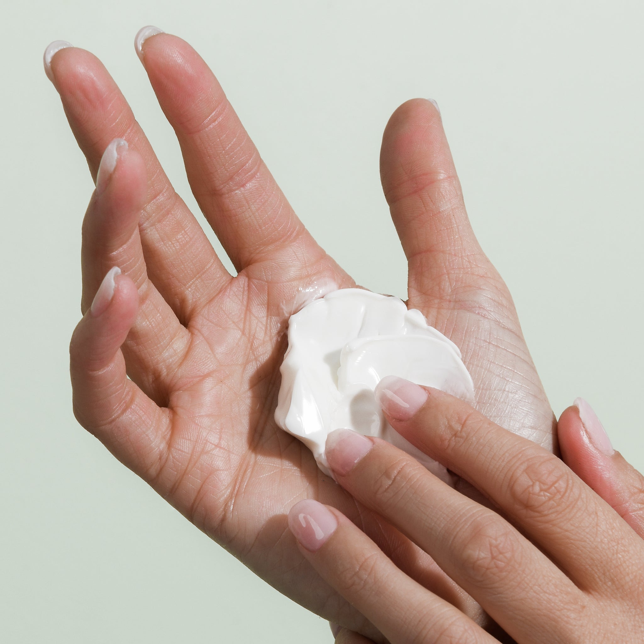 Hand rubbing Alivio Wellness day cream showing texture